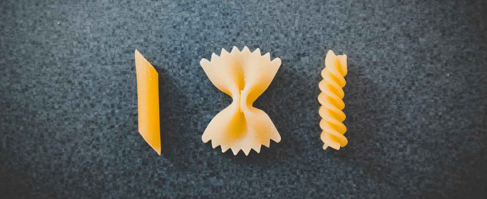 three different pieces of macaronis on top of black surface