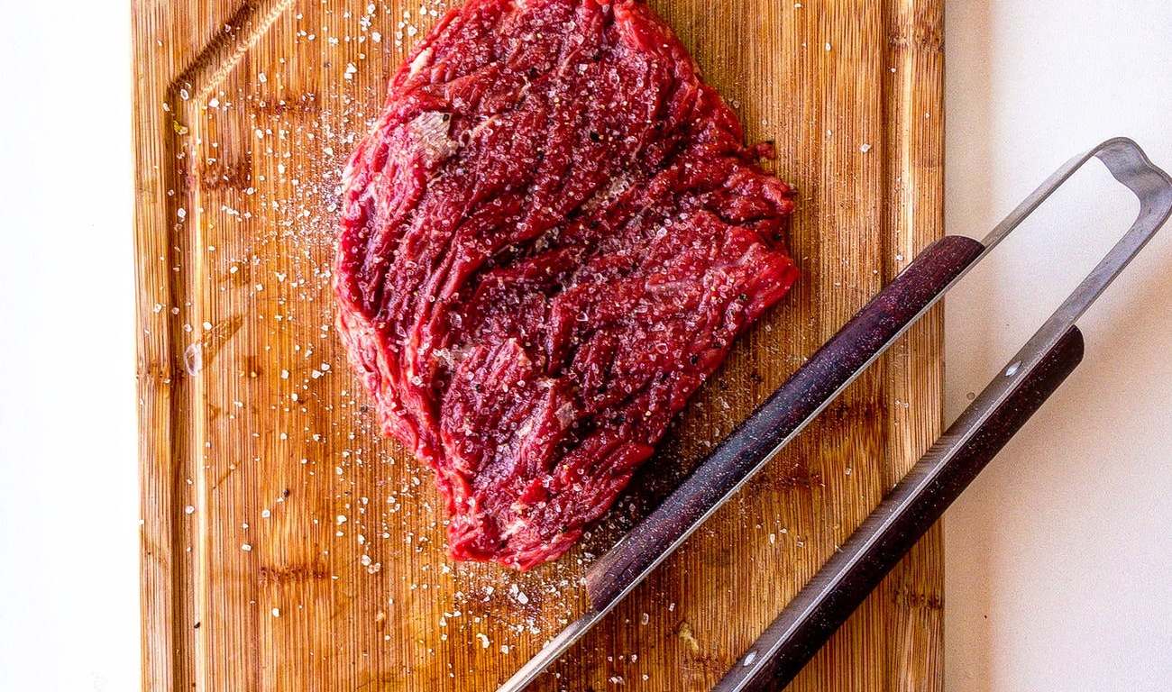 brown wooden chopping board with meat on top