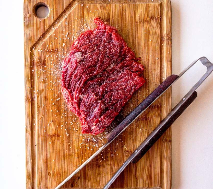 brown wooden chopping board with meat on top