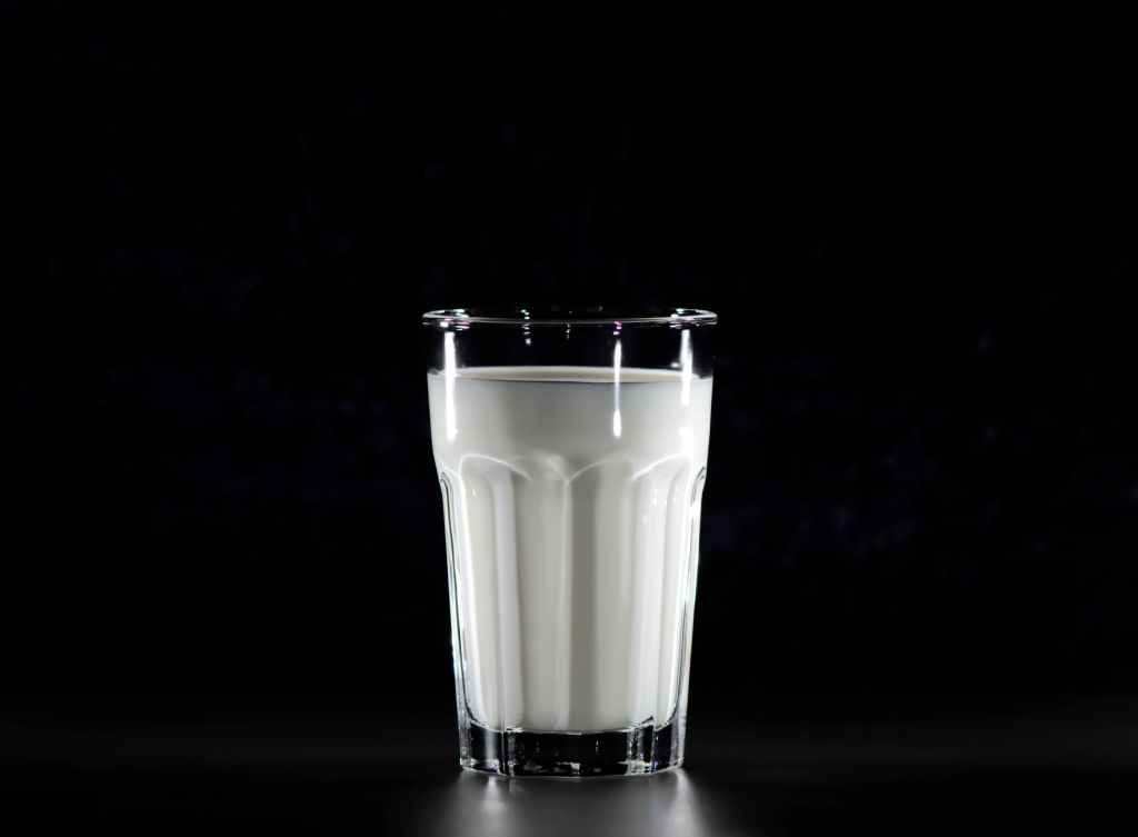 grayscale photography of glass of milk