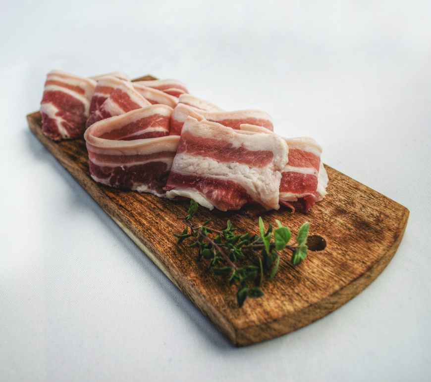 food photography of sliced bacon on top of brown chopping board