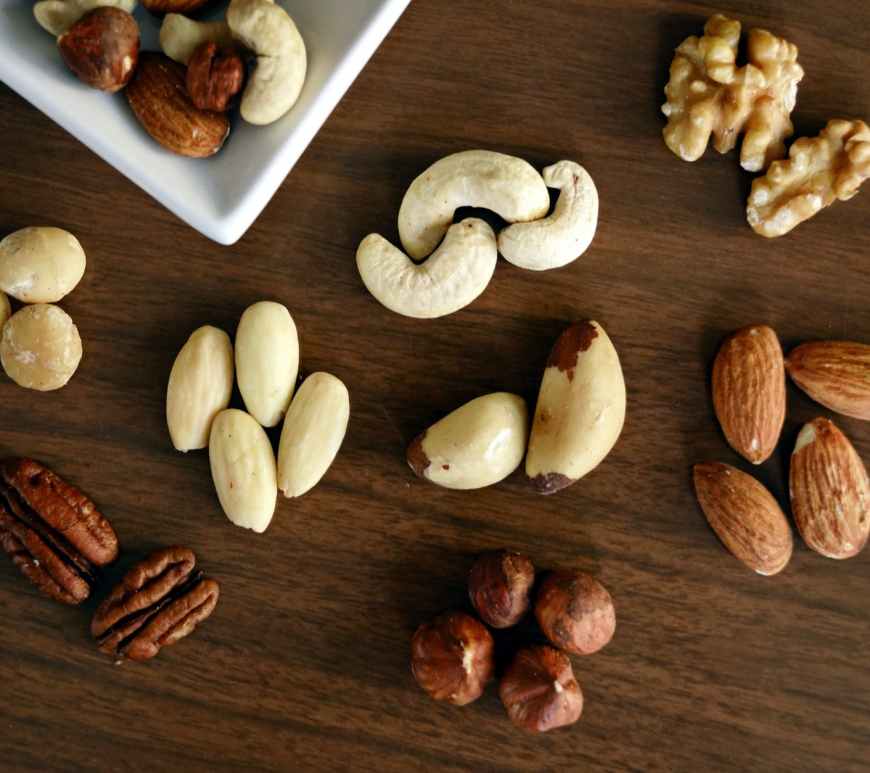 variety of brown nuts on brown wooden panel high angle photo